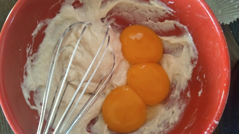 肉松小贝杯子蛋糕,用蛋抽十字搅拌，加入分离的蛋黄继续用蛋抽搅拌