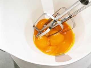 香蕉蛋黄溶豆,蛋黄3个放入无水无油的容器中（最好使用口径小一些的硅胶容器），使用电动打蛋器，隔着温水，开始中高速打发蛋黄。。