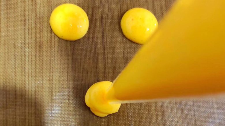 香蕉蛋黄溶豆,混合好的面糊装入一次性裱花袋，剪口后挤出小圆形。注意隔开挤。