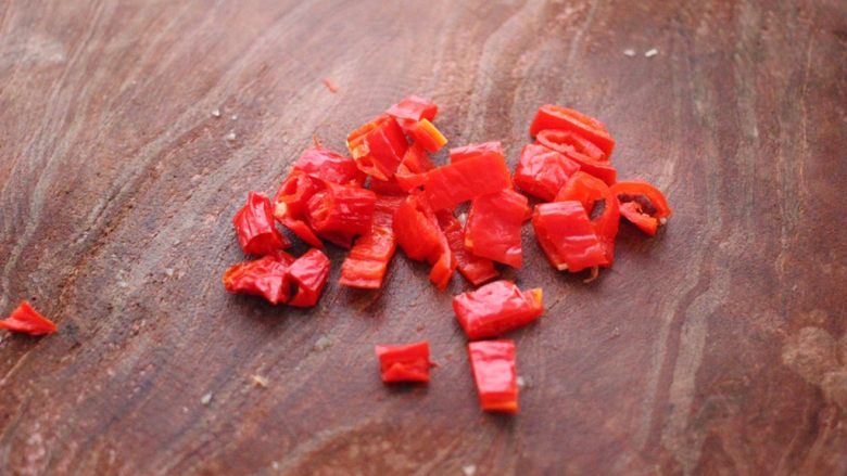 猪头肉拌黄瓜,把红辣椒用刀切成小块。