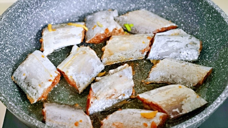 红烧带鱼,起油锅，将腌制好的带鱼段摆放在锅中。