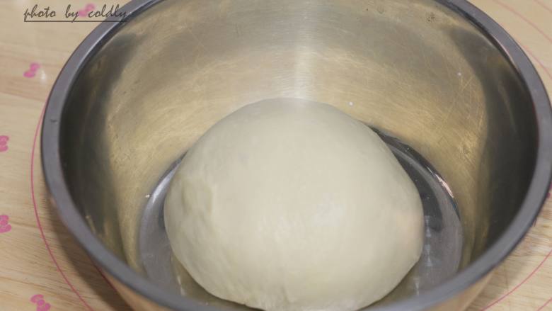 牛肉肠玉米面包,把面团取出滚圆放在盆里，盖上保鲜膜放在温暖处发酵
