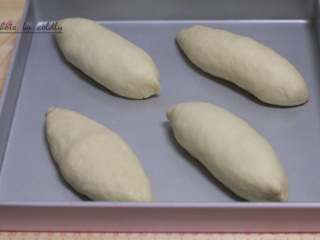 牛肉肠玉米面包,用双手握着两端来回揉搓成橄榄形，移至学厨Kitty烤盘放进烤箱发酵，烤箱里放一盆热水增加湿度