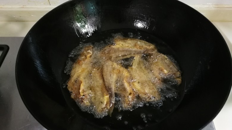 酥香小黄鱼,油锅再烧热，放入小黄鱼炸至金黄