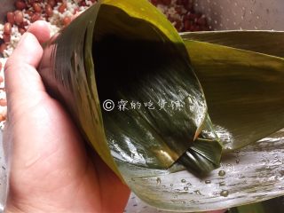 赤豆三角粽,取粽叶（根据粽叶的大小，取1或2张），一头卷成一个斗状（尖尖头的地方卷紧，不要有洞露出来）。