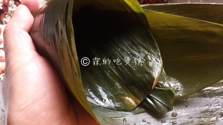 赤豆三角粽,取粽叶（根据粽叶的大小，取1或2张），一头卷成一个斗状（尖尖头的地方卷紧，不要有洞露出来）。