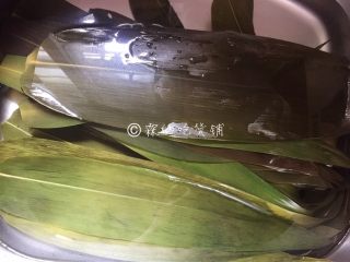 赤豆三角粽,粽叶，用开水浸泡（因为用的是干粽叶，所以要把它泡软，新鲜的直接洗净就可以，干粽叶烧出来会比新鲜的粽叶更香一点）。