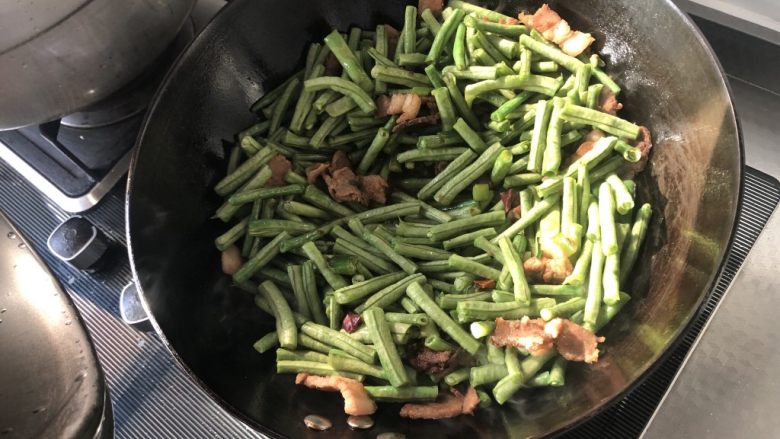 炒菜豆,加入菜豆和适量盐翻炒均匀，盖锅盖改小火