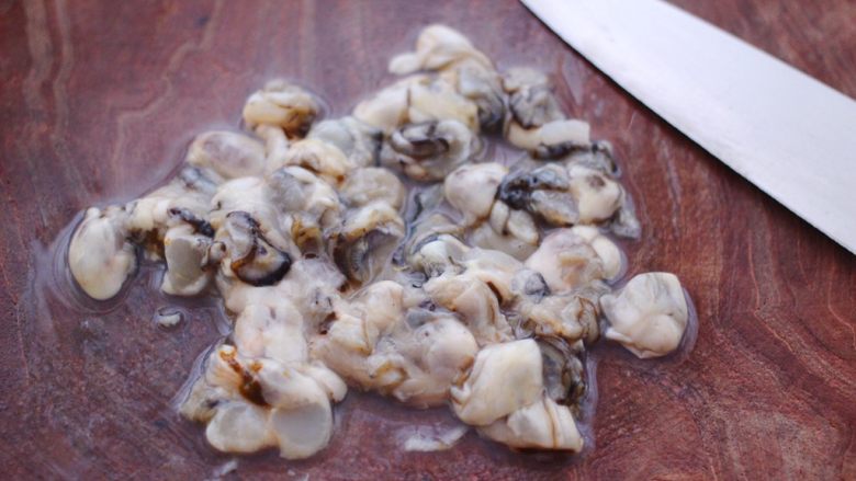 海蛎子西葫芦饺子,把洗净的海蛎子，用刀切成小块，我是一个海蛎子肉切了3下。