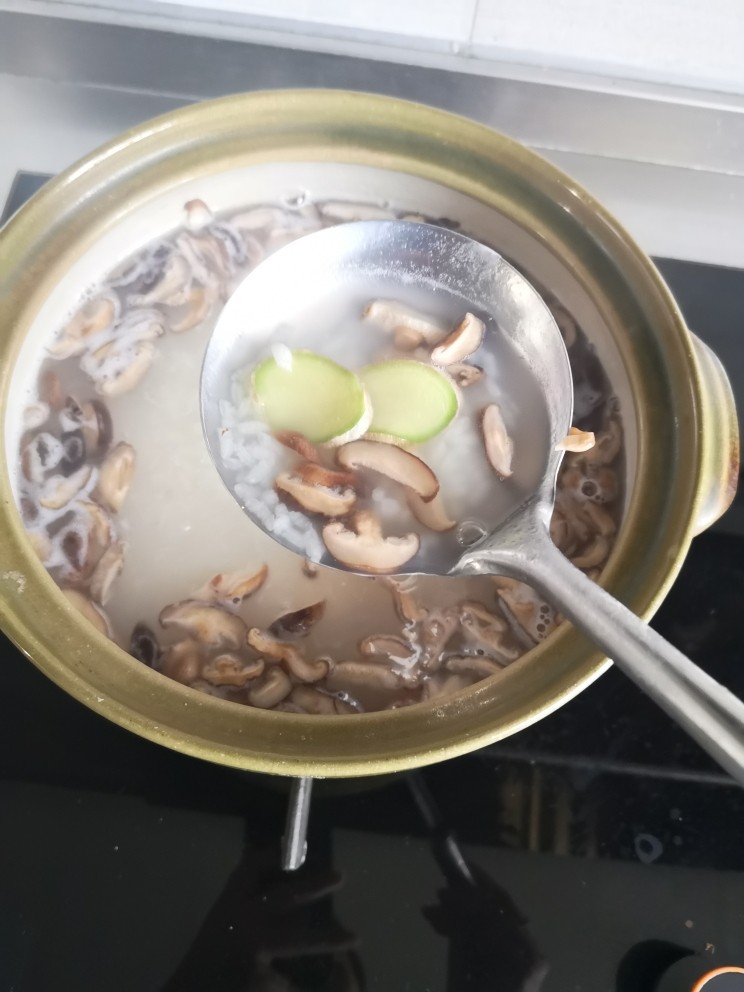 砂锅香菇鸡丁粥,粥熬制七成熟
放入香菇、生姜继续熬