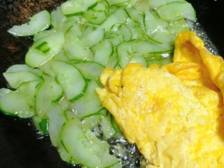 黄瓜炒鸭蛋,加煎好的鸡蛋，并用锅铲把煎蛋铲碎