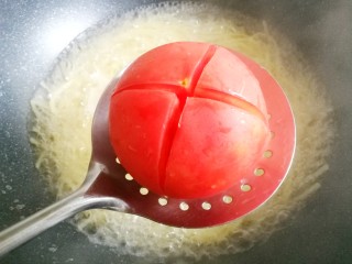 番茄火腿意面,番茄同样放入面汤中烫1分钟至皮开，捞出过凉撕开皮。