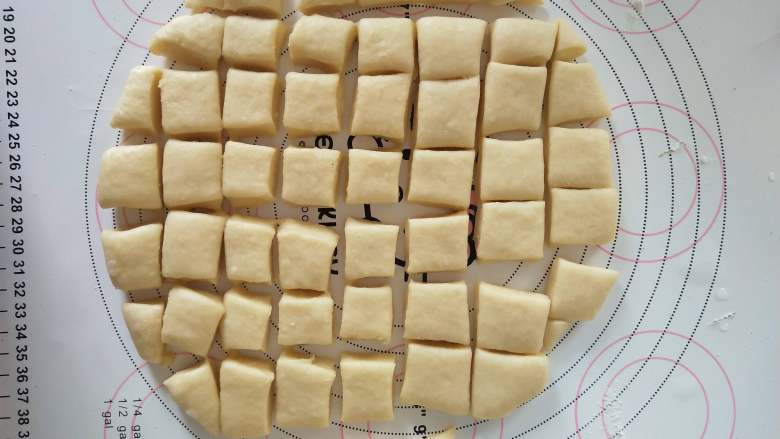 一口乳酪包,8，将面团擀成1厘米后的面片，切割成2乘以2厘米的小方块。
