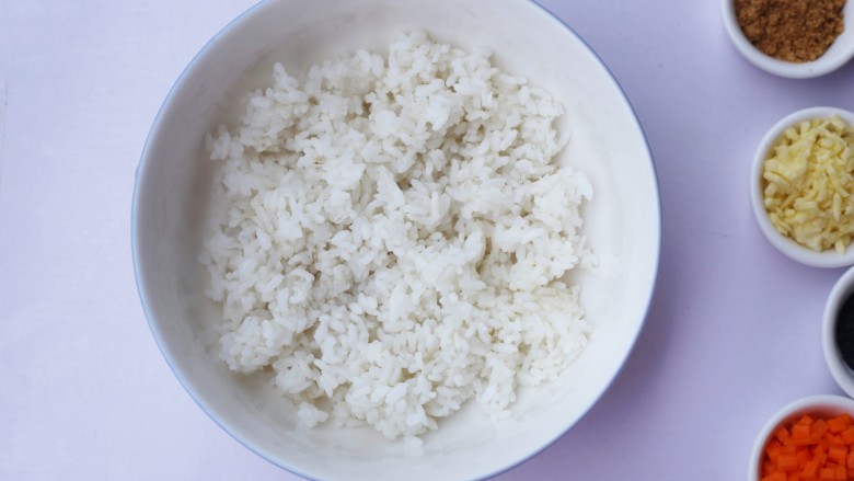 西兰花肉松芝士饭团,剩米饭倒入大碗中拌匀。