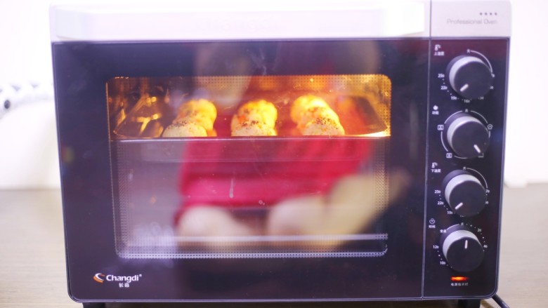 西兰花肉松芝士饭团,放入预热好的烤箱，200度上下火中层烤6分钟。