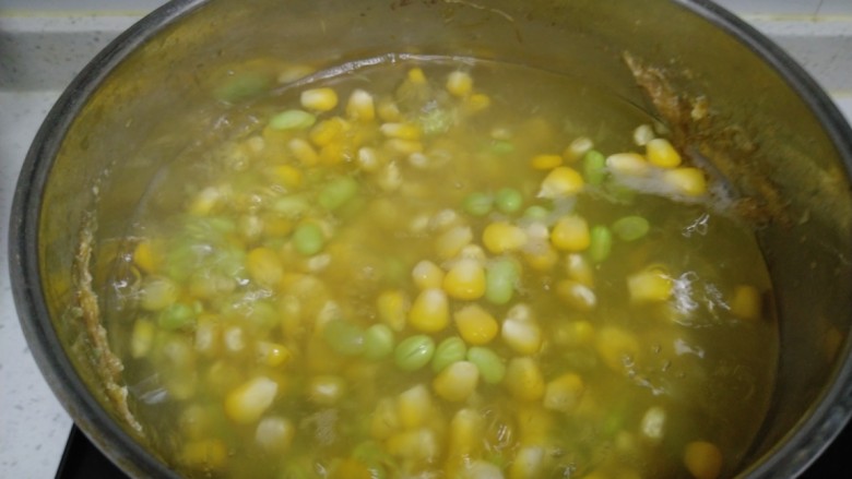 家常麦烧,锅中清水，放入玉米和青豆煮10分钟。