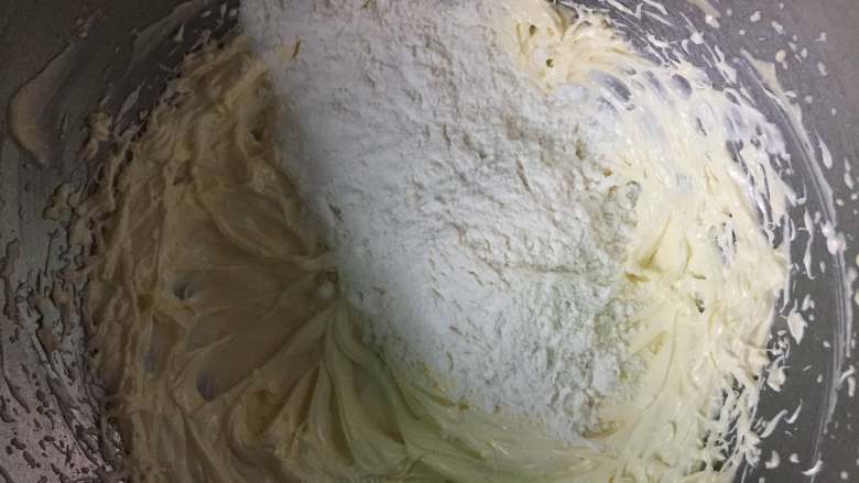 维也纳曲奇,把过筛的低筋面粉倒入到黄油糊中，用刮刀拌匀。