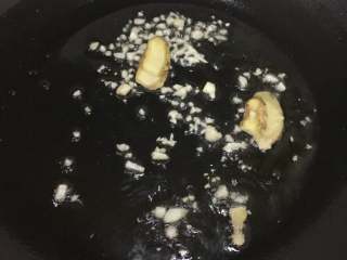 酸汤肥牛,锅烧热倒油，把大蒜、姜片放入炒出香味。