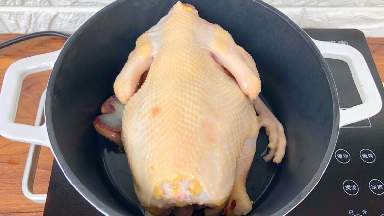 虫草花鸡汤,把鸡爪切下来，和鸡胗、鸡心一起放入珐琅小白锅里，再把洗干净的土鸡放到上面。