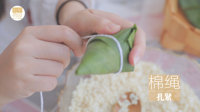 奶奶的碱水粽「厨娘物语」,用棉绳将粽子扎紧。