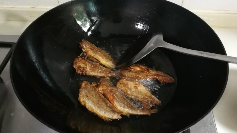 蒜香黄鱼,油锅再次烧热，放入小黄鱼复炸，炸至金黄