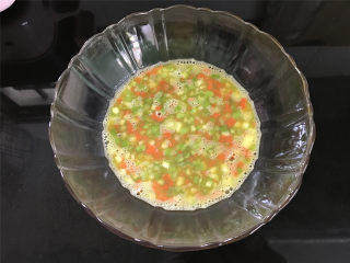 芦笋烘蛋,4个鸡蛋打入碗中，然后把切好的胡萝卜和芦笋粒放入碗中搅拌均匀。
