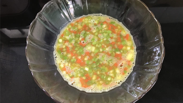 芦笋烘蛋,4个<a style='color:red;display:inline-block;' href='/shicai/ 9'>鸡蛋</a>打入碗中，然后把切好的胡萝卜和芦笋粒放入碗中搅拌均匀。