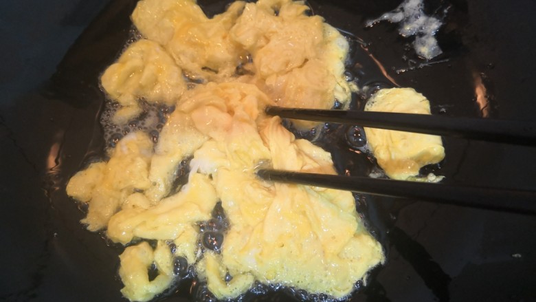 韭黄炒鸡蛋,用筷子划拨均匀，至鸡蛋液凝固定型，盛出备用