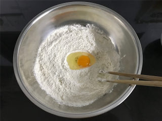 自制油条,1个鸡蛋打入250克油条粉中搅拌均匀再加入10克油一起拌匀。