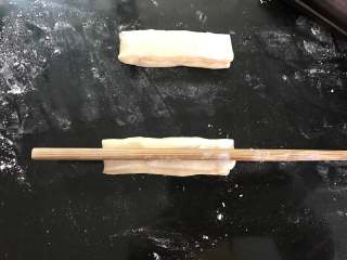 自制油条,把两个面条叠起来，用筷子在中间压出一条纹路。