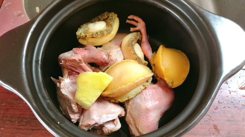 虫草鸽子鲍鱼汤,再把洗好的鲍鱼和鸽子放入砂锅中，放一块姜。