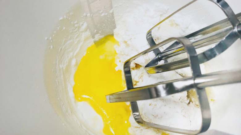 宝宝零食：小奶泡,将蛋液少量多次的倒入装有奶粉和面粉糊的容器中，使用电动打蛋器中低速混合，每次充分混合后再加入其余的蛋液。