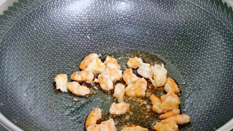 虾仁炒豇豆,起油锅加入腌制过的虾仁煸炒，炒制变色后盛出备用。