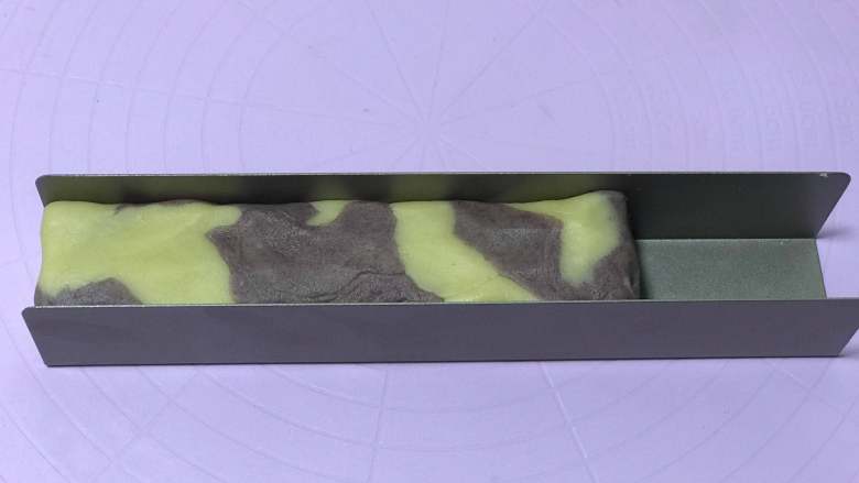 黑醋栗双色黄油饼干,卷起来整理一下，放入U型饼干模具里整理成柱状放入冰箱冷冻30分钟左右。（模具内最好铺上油纸方便脱模）