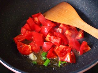番茄扇贝烩白玉菇,加入切块的番茄，大火快速翻炒均匀。