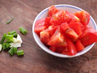 番茄扇贝烩白玉菇,把番茄洗净后，用刀切成小块，小葱切碎。