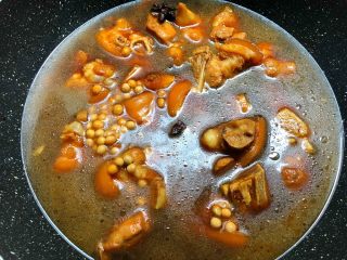 黄豆炖猪蹄,待汤汁焖干以后，加入适量水，水量超出食材2厘米左右，把黄豆倒入翻炒均匀，盖上盖子中火焖40分钟。
