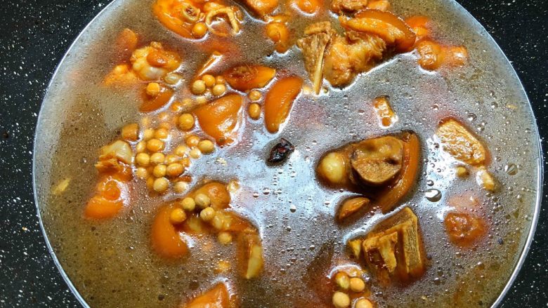 黄豆炖猪蹄,待汤汁焖干以后，加入适量水，水量超出食材2厘米左右，把黄豆倒入翻炒均匀，盖上盖子中火焖40分钟。
