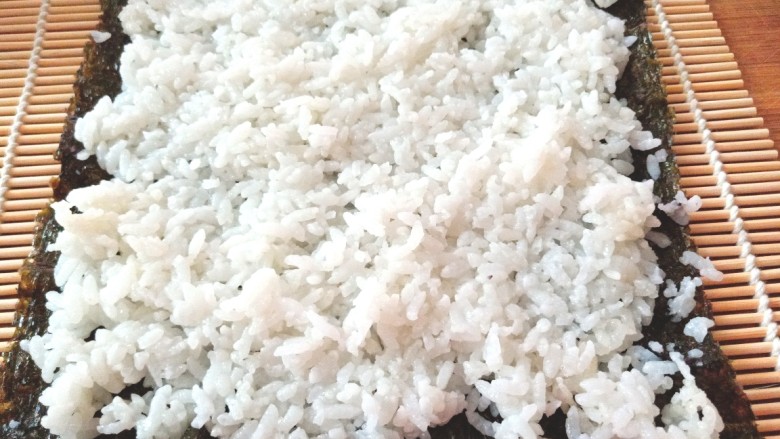 辣白菜肉松寿司卷,铺上米饭