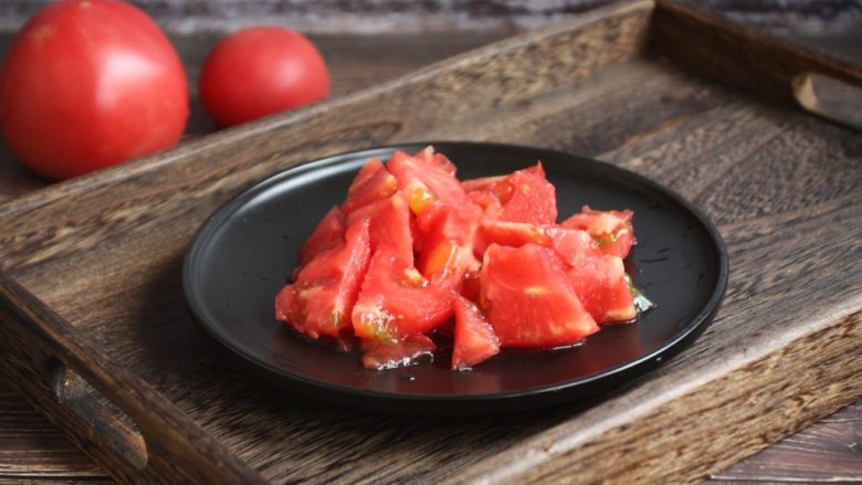 番茄鹅蛋炒豌豆卷心菜,将剥了皮的番茄切成小块。