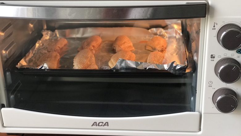 秘制烤鸡翅（鸡腿）,预热好后放入烤箱，鸡腿220度烤25分钟，鸡翅200度16分钟，中途取出翻面。