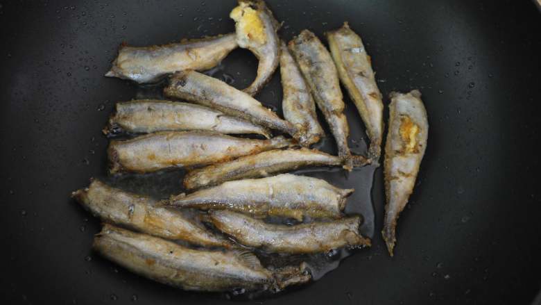 香煎多春鱼,把鱼翻面，把另外一边也煎至金黄色。记得不要开大火哦，不然很容易焦。