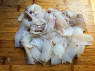 胡萝卜芦笋炒鱿鱼,把鱿鱼剪开，去掉内脏和软骨，再把外皮上那一层皮撕掉，清洗干净，打上十字花刀，切段待用。