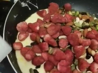 网红雪花酥,倒入草莓干和坚果搅拌，使它们和棉花糖均匀粘合在一起