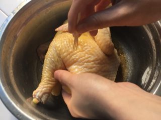 电饭煲烤鸡,用牙签把鸡肉扎扎，更好入味。再用黄酒给鸡做个按摩2分钟，放10分钟。