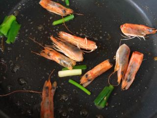 什锦虾仁粥,锅加少许油烧热，虾头和葱段放入翻炒出虾油