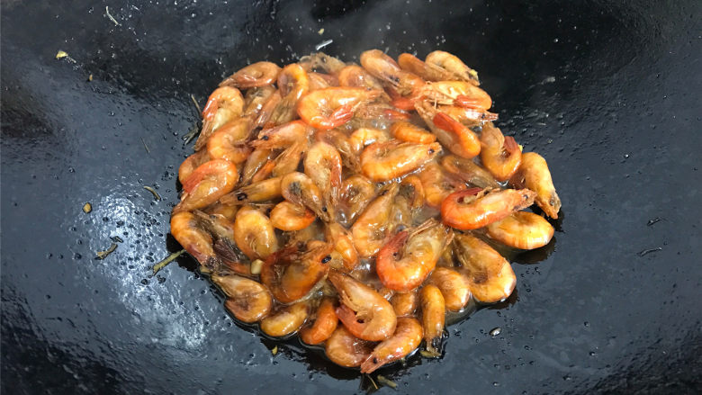 美极小河虾,把刚才炸好的虾再次倒入锅中，一起翻炒均匀后加少许水煮开。