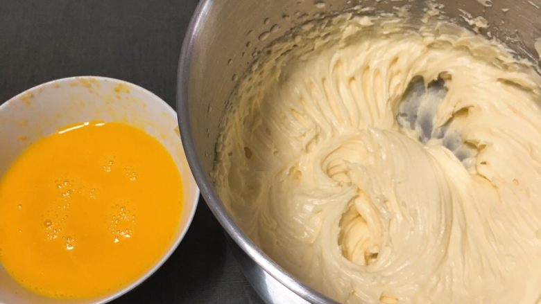 纽约芝士蛋糕,继续用打蛋器低速搅拌至顺滑，鸡蛋打散分三次加入，每加一次搅拌均匀后再加。
