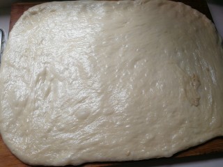野杏肉面包,手上抹油取出面团排气，压成厚面片