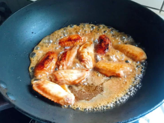 照烧鸡翅,中火烧热锅，将醃鸡翅的酱汁倒入，煮热后放入鸡翅，转中小火慢煮。煮的时候鸡翅要不时翻面，让两边都能入味。